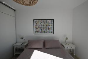 a bedroom with a bed and two tables with lamps at ALOHA Güemes Premium, 2 dorm con Vista a las Sierras in Córdoba