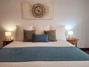 a bedroom with a large bed with two lamps at ZiRALLA in Allariz