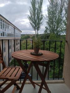 a wooden table with a potted plant on a balcony at ZiRALLA in Allariz