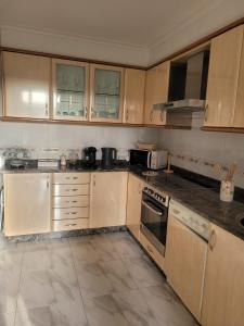 a kitchen with wooden cabinets and a stove top oven at ZiRALLA in Allariz