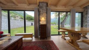 a living room with a table and large windows at Kulla e Andrrave in Ducaj