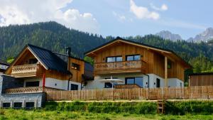 a house in the mountains with a wooden fence at das korda - Ferienhaus & Sommercard in Ramsau am Dachstein