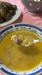 a spoon in a bowl of soup on a plate at Guest House Mene in Gjirokastër +28 photos