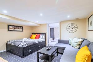 a living room with a bed and a couch at St Clair Hotel - Cozy Basement Suite with Parking in Toronto