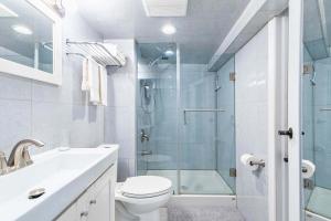 a bathroom with a shower and a toilet and a sink at St Clair Hotel - Cozy Basement Suite with Parking in Toronto