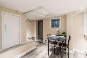 a kitchen and dining room with a table and chairs at St Clair Hotel - Cozy Basement Suite with Parking in Toronto