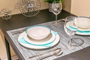 a table with plates and bowls and wine glasses at St Clair Hotel - Cozy Basement Suite with Parking in Toronto