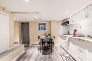 a kitchen with a table and chairs in a room at St Clair Hotel - Cozy Basement Suite with Parking in Toronto +15 photos