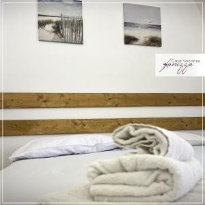 a bed with a white blanket and pictures on the wall at Rebecca e Sofia Stone House affittacamere in Alberobello +31 photos