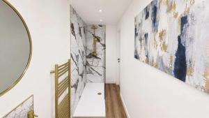 a hallway with paintings on the walls and a mirror at Bayview at the Port in Port Bannatyne