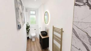 a bathroom with a toilet and a mirror on the wall at Bayview at the Port in Port Bannatyne