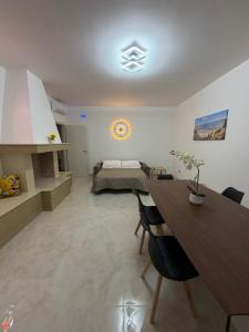 a living room with a bed and a table and chairs at Lu Sule lu Mare le Luci in Scorrano