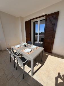 a dining room with a table and chairs and a window at Lu Sule lu Mare le Luci in Scorrano