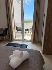 a bedroom with a bed with a view of a patio at Lu Sule lu Mare le Luci in Scorrano