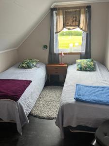 a bedroom with two beds and a window at Huset Heimstad i Herfjord in Skippervik