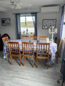 a dining room with a table and chairs and a table and a table and chairs at Huset Heimstad i Herfjord in Skippervik