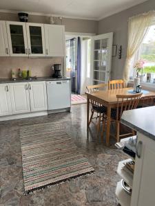 a kitchen with white cabinets and a table and a dining room at Huset Heimstad i Herfjord in Skippervik +9 photos