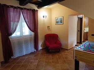 a living room with a red chair and a table at Villa Valle Tassignana in Casperia