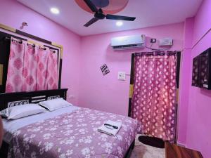 a bedroom with a pink room with a bed and curtains at ss luxe inn in Guntūr
