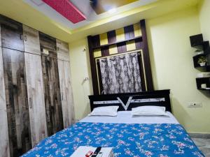 a bedroom with a bed with a blue comforter at ss luxe inn in Guntūr