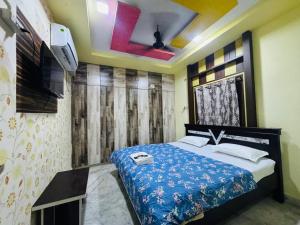 a bedroom with a bed and a tv on the wall at ss luxe inn in Guntūr