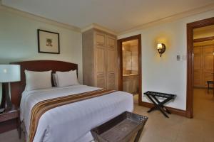 Un pat sau paturi într-o cameră la Crown Regency Suites Mactan