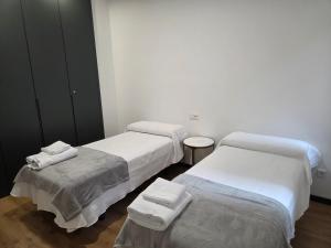 three beds in a room with white walls at Plaza España 2 in Alcazar de San Juan