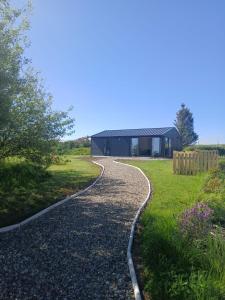 a gravel road leading to a black building at Meadow Suite in Lahinch