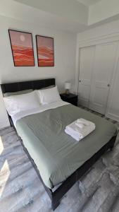 a bedroom with a bed with two towels on it at Stylish Townhome Gem with Several Amenities Just Minutes To The Falls in Niagara Falls