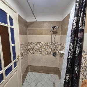 a bathroom with a shower with a shower curtain at dar Beya in Kairouan