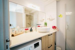 a bathroom with a sink and a mirror at La Perle Fleur d'Epée in Le Gosier +39 photos