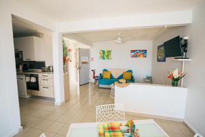 a living room with a couch and a kitchen at La Perle Fleur d'Epée in Le Gosier