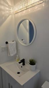 a white bathroom with a sink and a mirror at Stylish Townhome Gem with Several Amenities Just Minutes To The Falls in Niagara Falls +20 photos