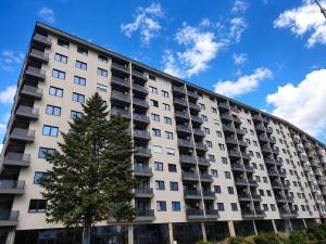 a tall building with a tree in front of it at Apartment Moki in Skopje
