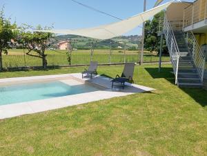 a pair of chairs sitting next to a swimming pool at Villa Gemma in Alba