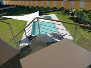 a balcony with a table and chairs and a pool at Villa Gemma in Alba
