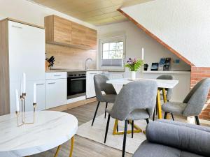 a kitchen and dining room with a table and chairs at ANKERHUUS Norddeich in Norddeich