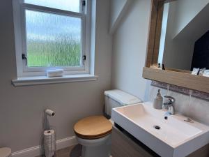 a bathroom with a toilet and a sink and a window at Daviot Lodge in Inverness +58 photos