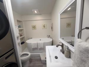 a bathroom with a tub and a toilet and a sink at School Village Walk-in shower and jetted tub in Elizabethtown +23 photos