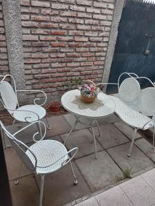 three chairs and a table with a potted plant on it at Casa in Santiago