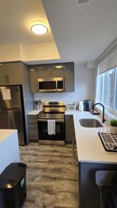 a kitchen with stainless steel appliances and a sink at Stylish Townhome Gem with Several Amenities Just Minutes To The Falls in Niagara Falls
