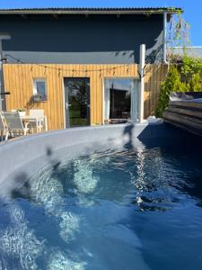 a swimming pool with blue water in front of a house at Stodoła in Postomino