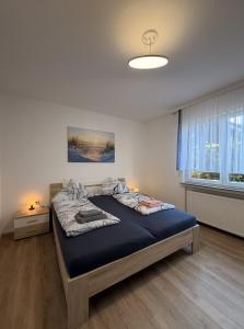 a bedroom with a large bed with a blue blanket at Haus Kormoran Borkum in Borkum
