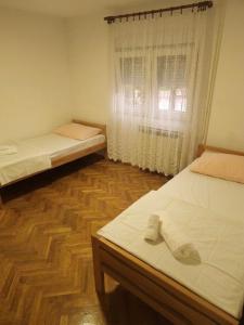 a room with two beds and a window at Vikendica Tobi in Čapljina