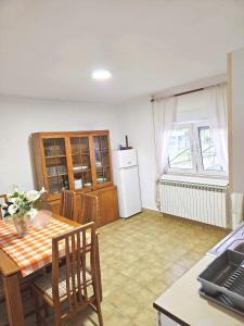 a kitchen and dining room with a table and a refrigerator at Vikendica Tobi in Čapljina