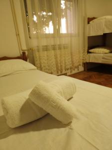 a white towel laying on top of a bed at Vikendica Tobi in Čapljina