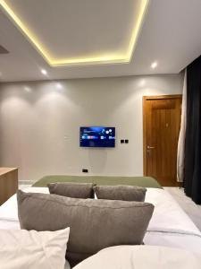 a bedroom with a bed with pillows and a tv on the wall at Starella Apartments in Lekki