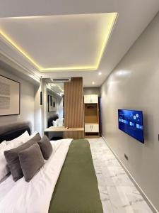 a bedroom with a large bed with a flat screen tv at Starella Apartments in Lekki