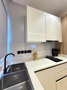 a kitchen with white cabinets and a sink at Starella Apartments in Lekki