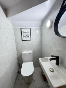 a bathroom with a white toilet and a sink at Starella Apartments in Lekki